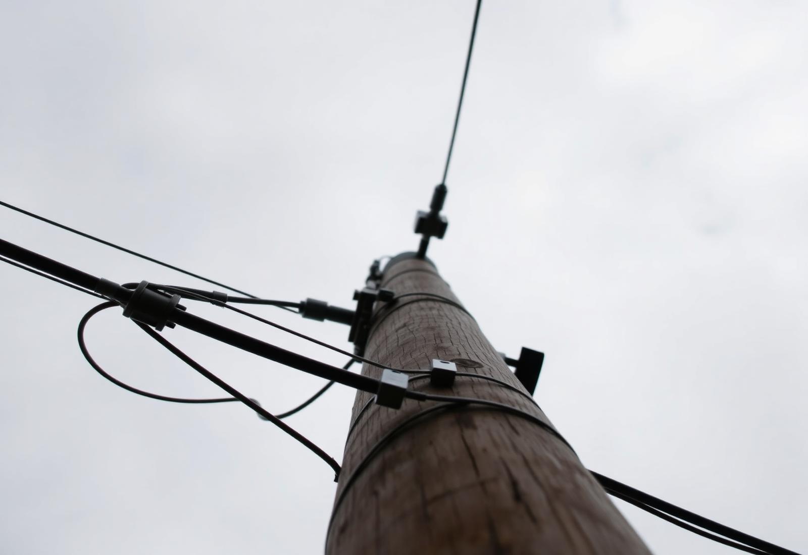 Aerial fiber attachment hardware mounted on a utility pole